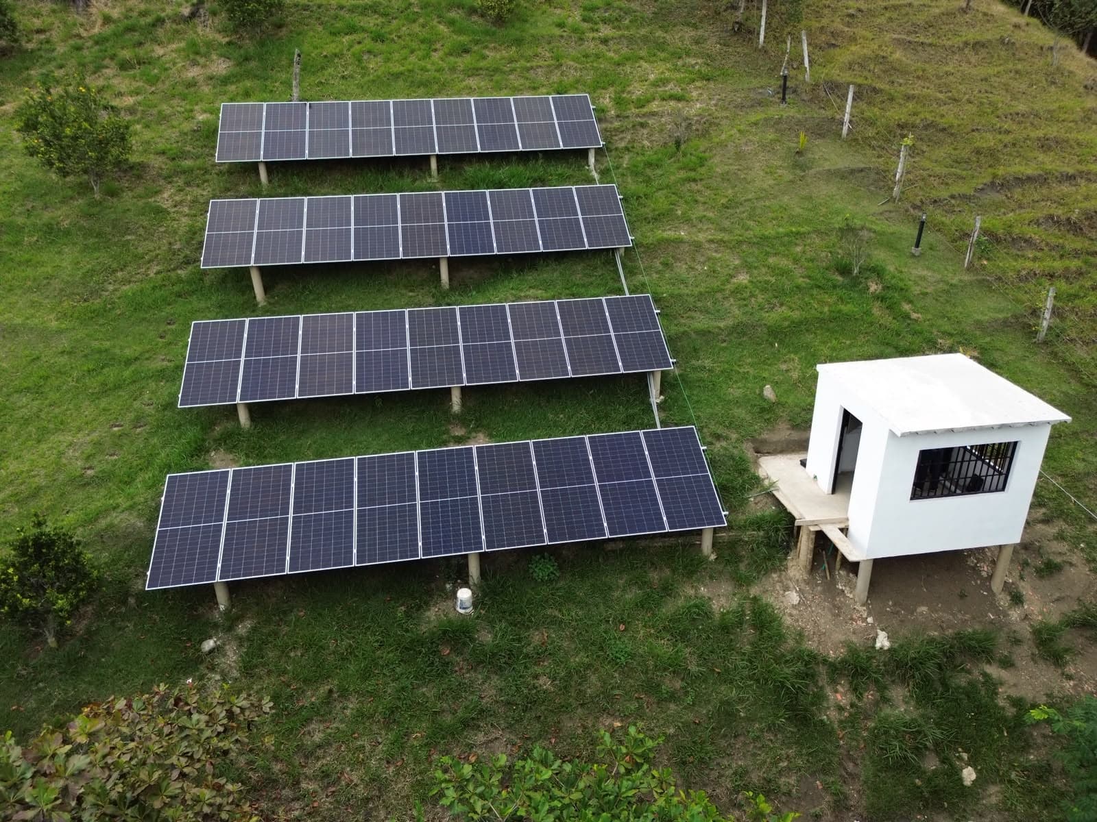 Cuatro mesas de paneles solares en ladera y cuarto técnico del Hotel Takuara, Vergara